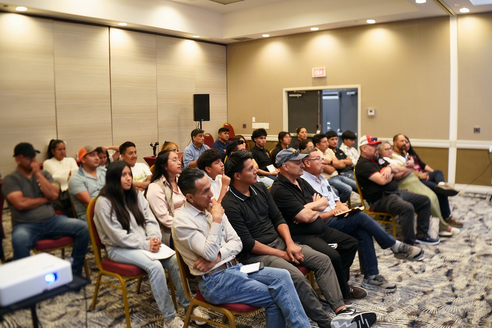 Sala llena de contratistas atentos al escenario
