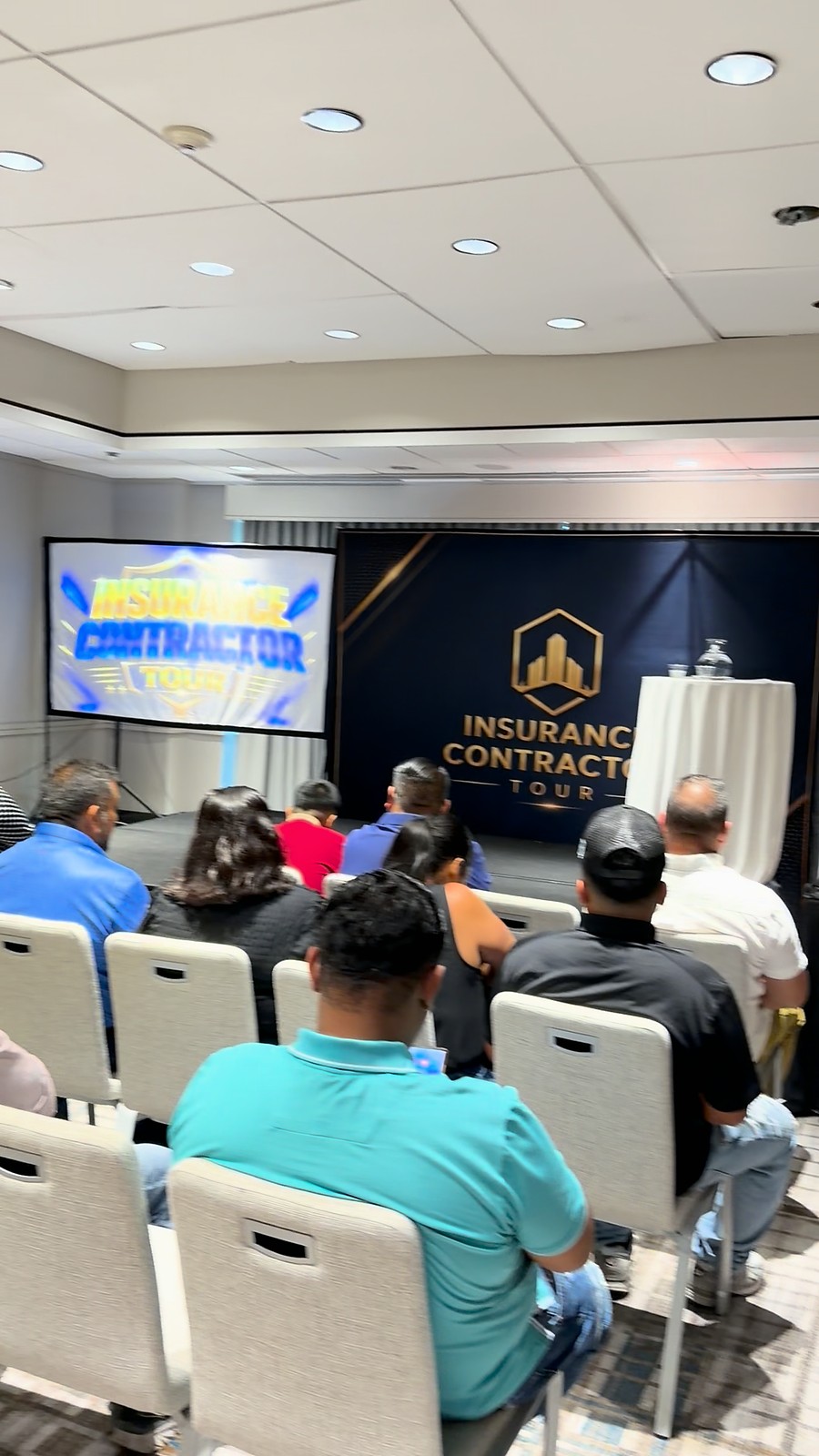 Sala del evento con la pantalla del Insurance Contractor Tour